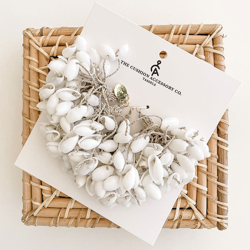 white cotton cushion with shell tassels. Perfect for coastal decorating in your coastal home. coastal shell tassels