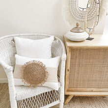 Load image into Gallery viewer, White boho cushion with stone natural colour strip wrapped around the cushion with a woven raffia disk attached to the front. The perfect Boho Accessory.
